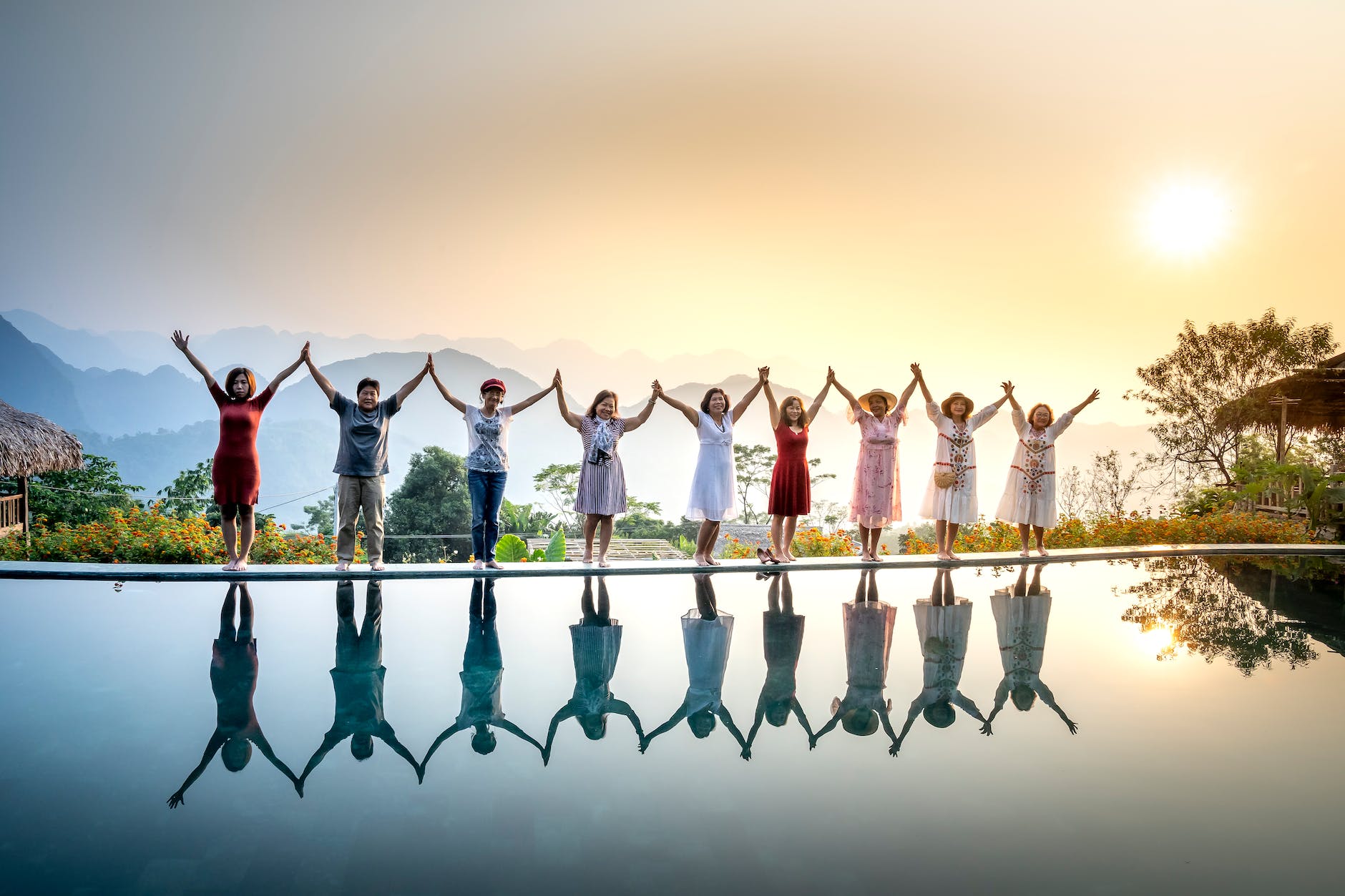 satisfied people gathering on poolside on sunset